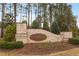 Stone monument sign for Stonemont community, surrounded by manicured greenery and trees at 105 Mystic Quartz Ln, Holly Springs, NC 27540