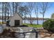 Backyard with storage shed and lush lawn leading to a lake at 106 Nashua Cv, Louisburg, NC 27549