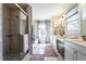 Bright bathroom featuring a glass shower, dual sinks, and a large window for plenty of natural light at 106 Nashua Cv, Louisburg, NC 27549