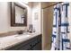 Bathroom featuring granite countertop, framed mirror and patterned shower curtain at 106 Nashua Cv, Louisburg, NC 27549