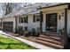 Inviting home entrance with brick steps, dark trim and manicured landscaping at 106 Nashua Cv, Louisburg, NC 27549
