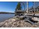 Outdoor patio with seating area featuring a stone fire pit next to the lake at 106 Nashua Cv, Louisburg, NC 27549