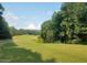 Beautiful view of the golf course with green fairways and mature trees in the background at 106 Nashua Cv, Louisburg, NC 27549
