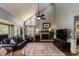 Living room with high ceilings, brick fireplace, large rug, and comfortable leather seating at 106 Nashua Cv, Louisburg, NC 27549