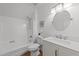 Bright bathroom featuring white fixtures, including a shower-tub combo and a vanity with a round mirror at 1208 Turner Farms Rd, Garner, NC 27529