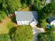 Stunning aerial view of a home with a manicured lawn, mature trees, private driveway, and a well-maintained roof at 1222 Dixie Trl, Raleigh, NC 27607