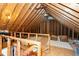Spacious attic featuring exposed beams, plywood flooring, and a well-lit area, perfect for storage or a bonus room at 1222 Dixie Trl, Raleigh, NC 27607