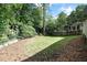 Serene backyard showcasing a lush lawn, mature trees, and privacy, creating an inviting outdoor oasis at 1222 Dixie Trl, Raleigh, NC 27607