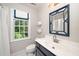 Bathroom features a navy blue vanity and a bamboo-framed mirror at 1222 Dixie Trl, Raleigh, NC 27607