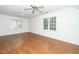 Spacious bedroom featuring hardwood floors, ceiling fan, and large windows with natural light at 1222 Dixie Trl, Raleigh, NC 27607