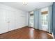 Bright bedroom with hardwood floors, large windows with woven shades, and white walls at 1222 Dixie Trl, Raleigh, NC 27607