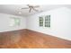 Large room with hardwood floors, ceiling fan, and two windows at 1222 Dixie Trl, Raleigh, NC 27607