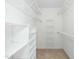 Walk-in closet featuring white shelving units and carpeted floors at 1222 Dixie Trl, Raleigh, NC 27607