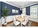 Elegant dining room featuring blue accent walls, wainscoting, and a stylish chandelier at 1222 Dixie Trl, Raleigh, NC 27607