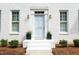 Elegant front entrance with powder blue door, decorative columns, and lush landscaping at 1222 Dixie Trl, Raleigh, NC 27607