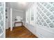 Entry hallway with white trim, beautiful wallpaper, hardwood floors and access to a room with shuttered doors at 1222 Dixie Trl, Raleigh, NC 27607