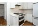 Modern kitchen featuring white cabinets, marble countertops, and stainless steel double oven at 1222 Dixie Trl, Raleigh, NC 27607