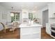 Bright, white kitchen featuring an island, modern appliances, a breakfast nook, and hardwood floors at 1222 Dixie Trl, Raleigh, NC 27607