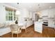 Bright, all-white kitchen with an island, modern appliances, hardwood floors, and a breakfast nook at 1222 Dixie Trl, Raleigh, NC 27607
