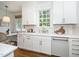 Bright kitchen features white cabinets and stainless appliances and white marble countertops and backsplash at 1222 Dixie Trl, Raleigh, NC 27607