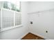 Laundry room with hardwood floors, shelving, utility connections, and a window at 1222 Dixie Trl, Raleigh, NC 27607