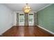 Beautiful living room featuring hardwood floors, three large windows, and an ornate chandelier at 1222 Dixie Trl, Raleigh, NC 27607
