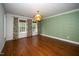 Elegant living room boasting hardwood floors, an ornate chandelier, and three large windows at 1222 Dixie Trl, Raleigh, NC 27607