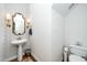 Powder room featuring pedestal sink, gold mirror and decorative wallpaper at 1222 Dixie Trl, Raleigh, NC 27607