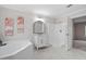 Bathroom featuring a white bathtub, shower, marble flooring, and vanity sink at 125 Vance Wrenn Rd, Roxboro, NC 27573