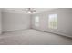 Bedroom with two windows, a ceiling fan, neutral carpet, and ample natural light at 125 Vance Wrenn Rd, Roxboro, NC 27573