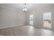 Bright dining room featuring modern lighting, two windows, and light-colored wood flooring at 125 Vance Wrenn Rd, Roxboro, NC 27573