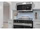 Close up of the black oven and microwave in a bright kitchen with light blue backsplash at 125 Vance Wrenn Rd, Roxboro, NC 27573