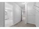 Bright walk-in closet space with built-in shelving and a view to a nearby, updated bathroom with shower at 125 Vance Wrenn Rd, Roxboro, NC 27573