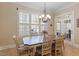 Elegant dining room with a chandelier, large windows, and seating for six at 1412 Wynncrest Ct, Raleigh, NC 27603