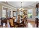 Formal dining room with wood floors, large windows, and seating for eight at 1412 Wynncrest Ct, Raleigh, NC 27603