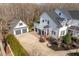 Aerial view of a lovely home featuring an expansive driveway and three-car garage at 1412 Wynncrest Ct, Raleigh, NC 27603