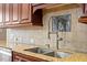 Close up of a kitchen featuring granite countertops, stainless steel sink and tile backsplash at 1412 Wynncrest Ct, Raleigh, NC 27603