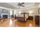 Spacious primary bedroom featuring hardwood floors, fireplace, tray ceiling, and recessed lighting at 1412 Wynncrest Ct, Raleigh, NC 27603