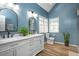 Bathroom with dual sinks, a walk-in shower, and stylish blue walls and flooring at 1701 Point Owoods Ct, Raleigh, NC 27604