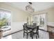 Bright dining room featuring large window, french doors, modern lighting fixture and a black table with four chairs at 1701 Point Owoods Ct, Raleigh, NC 27604