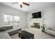 Spacious living room with a fireplace, large windows, and a ceiling fan at 1701 Point Owoods Ct, Raleigh, NC 27604