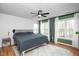 Main bedroom featuring hardwood floors, large windows with curtains and a ceiling fan at 1701 Point Owoods Ct, Raleigh, NC 27604