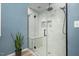 Modern shower featuring white tiles, a built-in bench, and sleek glass doors at 1701 Point Owoods Ct, Raleigh, NC 27604