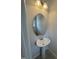 A sleek pedestal sink, oval mirror and modern lighting in a well-lit half bathroom at 184 Bruce Dr, Dunn, NC 28334