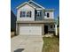 Charming two-story home with brick accents, a white garage door, and manicured landscaping at 184 Bruce Dr, Dunn, NC 28334