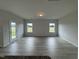 Living room with light gray wood-look flooring, windows, and neutral-painted walls at 184 Bruce Dr, Dunn, NC 28334