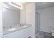 Bathroom featuring double sinks with granite countertop, white cabinets, and glass-enclosed shower, and wood-look tile floors at 2121 Wildwind Dr, Graham, NC 27253