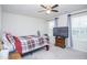 This bedroom features a ceiling fan, a cozy bed, and a mounted TV with two large windows at 2121 Wildwind Dr, Graham, NC 27253
