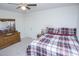 This bedroom features a ceiling fan, a cozy bed, a wooden dresser, and neutral walls and carpet at 2121 Wildwind Dr, Graham, NC 27253