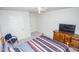 This bedroom features a ceiling fan, a cozy bed, a wooden dresser, and neutral walls and carpet at 2121 Wildwind Dr, Graham, NC 27253